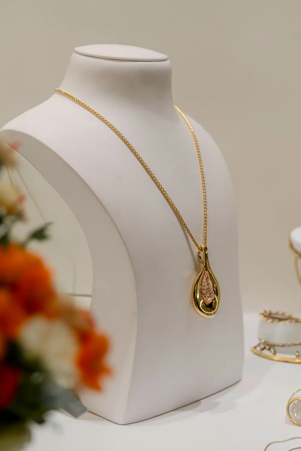 Femme portant des colliers dorés de différentes longueurs pour mettre en valeur son décolleté